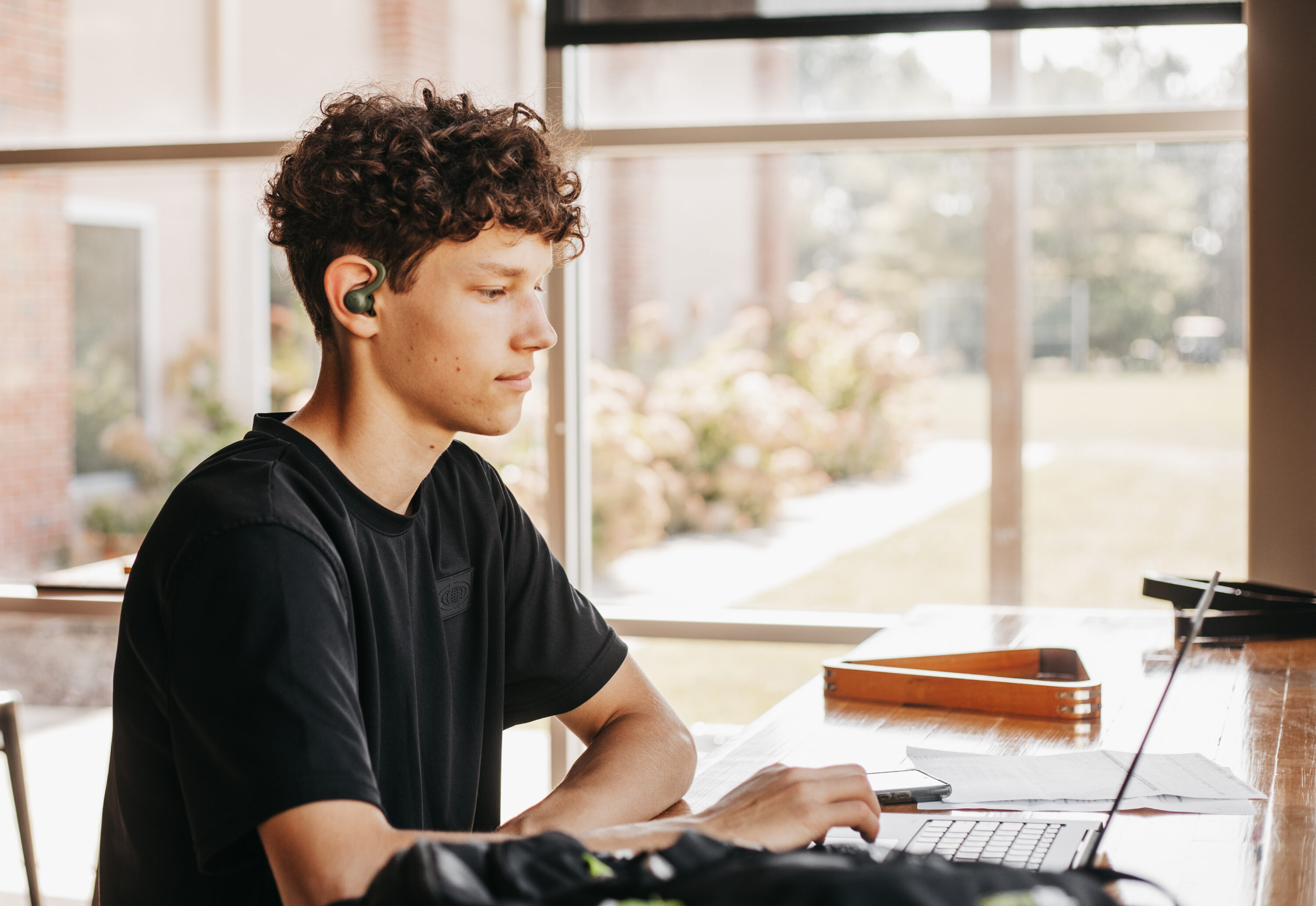 Student studying at a table with a laptop.