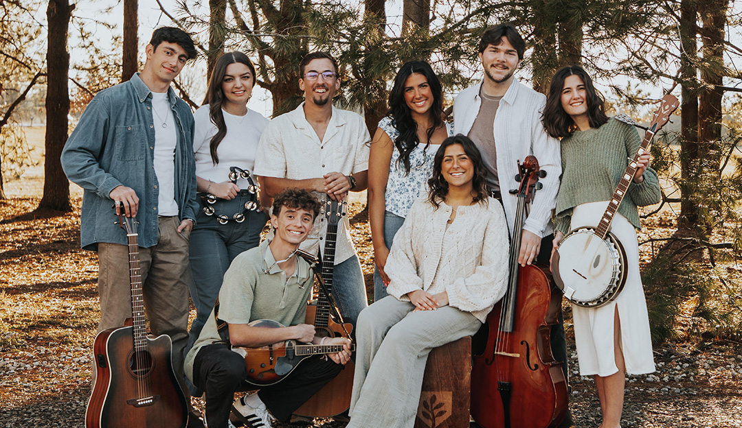 RBC students in Salt and Light pose with their instruments with trees in the background