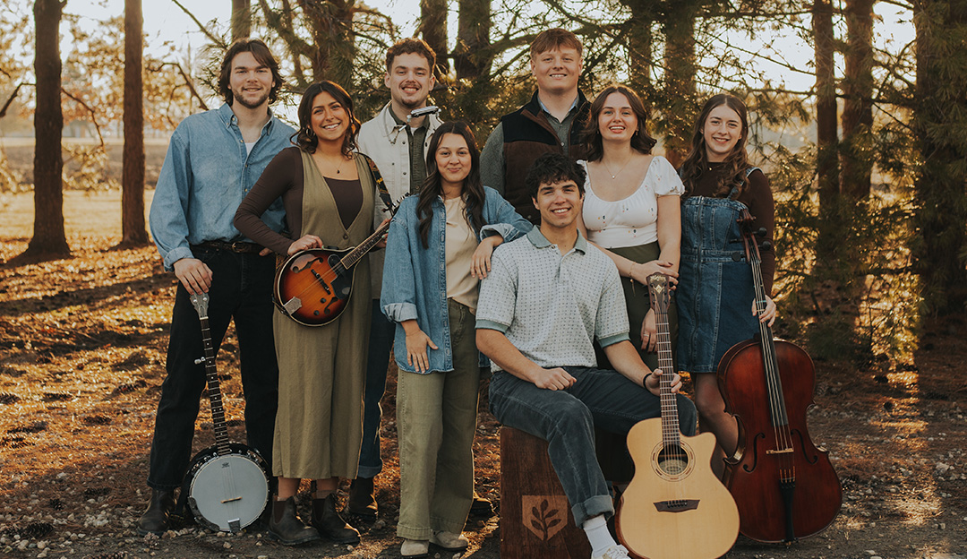 RBC students in Salt and Light pose with their instruments with trees in the background