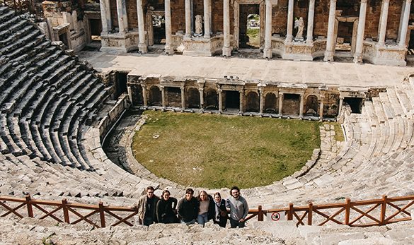 Six students standing in a circular ruin